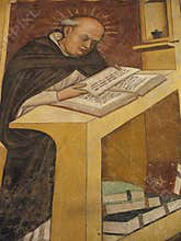 A Medieval monk in a scriptorium copies a manuscript