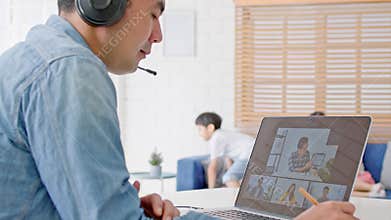 Asian father video call conference, online remote meeting with business coworker, with family in living room