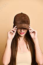 Sexy beautiful brunette woman in a brown suede baseball cap