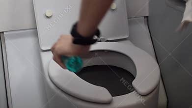 Close up female hand wiping aircraft lavatory toilet bowl, cleaning habit, bacteria on airplane restroom door, corona virus covid1