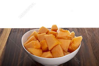 Close-up of a white bowl full of sliced cantaloupe