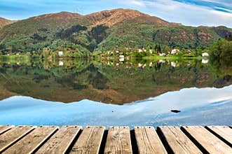 Wood Texture and Beautiful Summer Landscape Background with Green Trees, Mountains and Mirror Lake Reflection