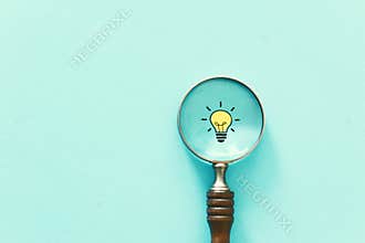 Business concept image. Magnifying glass and lamp. Finding the best idea and inspiration among others