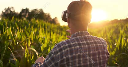 Smart farming with IoT, futuristic agriculture concept : Farmer wears VR or AR glasses while monitoring rainfall