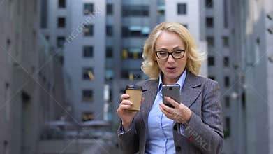 Senior office worker looking excited reading good news smartphone, business app
