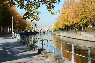 Promenade le long du quai Notre-Dame a Tournai en Belgique en automne. Pont des trous en perspective