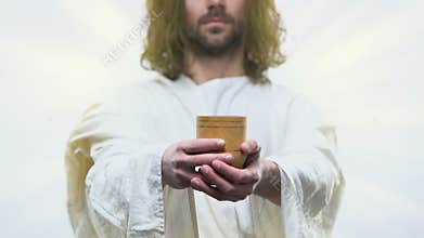 Merciful Jesus reaching out hands with wooden glass giving fresh water to people