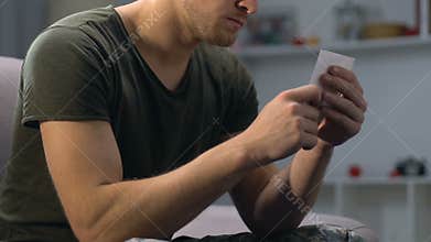 Army soldier looking at girlfriend photo, missing wife, romantic feelings, love
