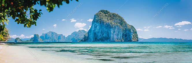 Bay beach and mountains isles panorama in Palawan Philippines Islands view from turquoise shallow sea at sunny day