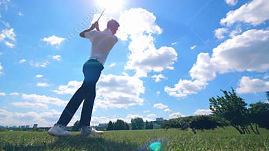 Golf course with a man strongly striking the ball
