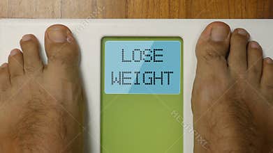 Closeup male feet on scale LOSE WEIGHT display at morning 4k footage top view