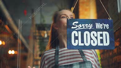 Cheerful waitress changing closed to open sign smiling waiting for customers