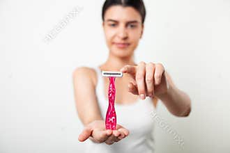 Woman hold pink razor for hair removal