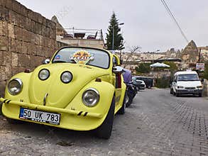 Goreme, Turkey - October 2019. Yellow old time car parked on the paving street of the Cappadocia