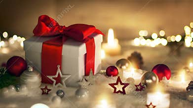 Christmas gift with snow, candles and ornaments