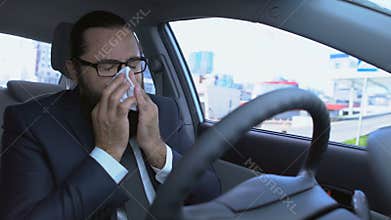 Man sneezing using tissue, suffering allergy while driving car, flu symptom