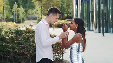 Mixed-race woman starts crying during the quarrel with her boyfriend in the street.
