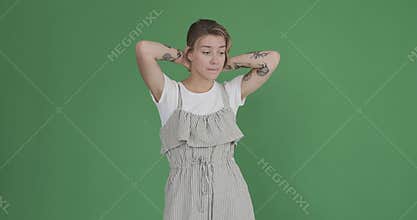 Tattooed woman coming up with a brilliant idea over green background