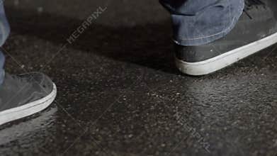 Man walking on concrete in rain at night
