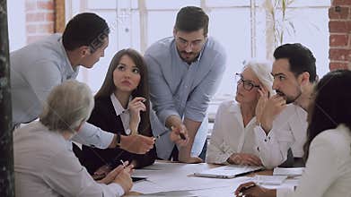 Male mentor training employees group explaining work plan at meeting