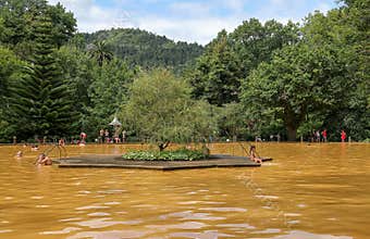 People swimming in a mineral thermal pool in the Terra Nostra botanical garden at Furnas, SãoMiguel island, Azores.