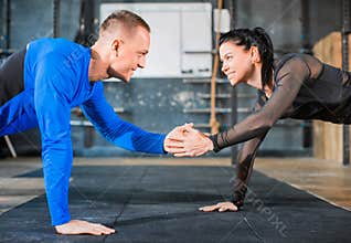 Push-ups together. Healthy couple in gym, workout with own body weight. Close ip photo.