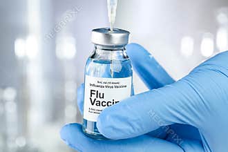 Healthcare concept with a hand in medical gloves holding Flu, Influenza, vaccine vial