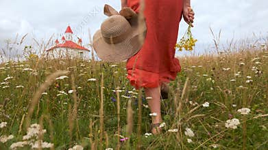 Woman walking toward small chapel on hill top