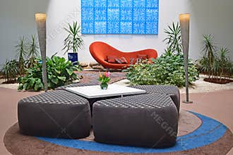 Indoor garden with natural light of a luxury hotel resort lobby with designer sofa surrounded by green plants