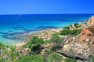Way to a very nice beach in Portugal called Praia da Falesia with a scenic walkway a big red rocks in the background