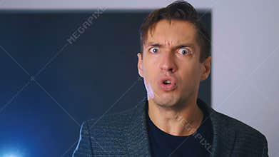 Angry businessman yelling at camera closeup. Aggressive man yells at the interlocutor, threatening with his finger. The