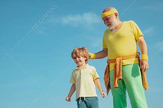 Grandfather giving grandson ride on back in park. Father and child training together. Sport yoga and fitness. Motivation