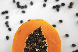 Half cut ripe papaya with seed on a white plate. Slices of sweet papaya with a white background. Halved papayas. Healthy