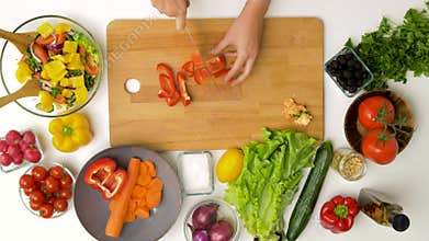 Young woman chopping pepper for salad at home