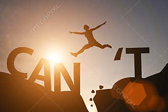 Silhouette man jump between can`t wording and can wording on mountain. Mindset for career growth business