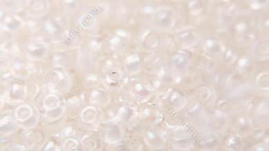 Pouring white clear beads into a white plate.