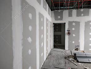 Drywall installation work in progress by construction workers at the construction site.