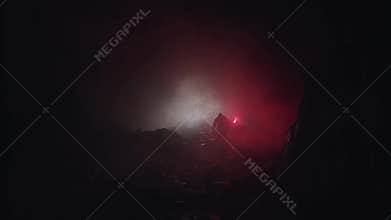 Silhouette of a geologist examining dark cave, holding red signal flare. Stock footage. Scientist man exploring stony