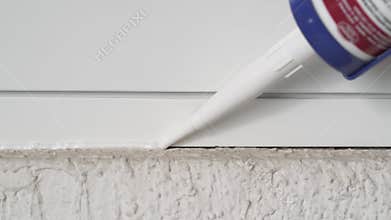 Man applying silicone sealant with caulking gun