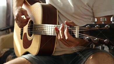 The musician plays a fast rhythm on a yellow acoustic guitar. The concept of music and creativity.