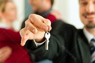 Couple receiving keys from real estate broker