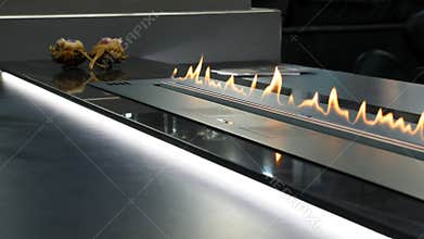 Modern home interior with bio fireplot fireplace on the desk.