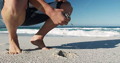 Man crouching on the beach