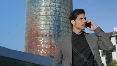 Businessman arguing on phone at street. Male employee talking on smartphone