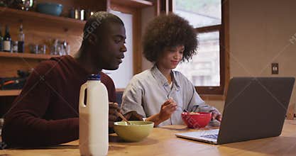 Couple watching computer while having breakfast