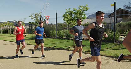 Men running outside on sunny day