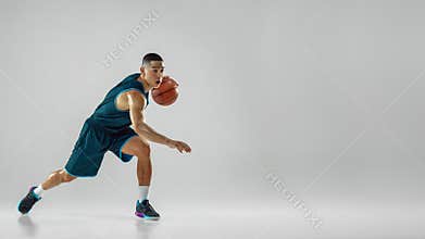 Young basketball player training isolated on white studio background