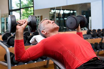 Exercising with dumbells at gym