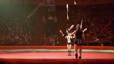 The Duo of Twin Girls Juggle with Clubs Performs Tricks on the Circus Stage