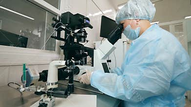 Coronavirus epidemia, virus vaccine concept. Female expert is operating a microscope in the lab facility